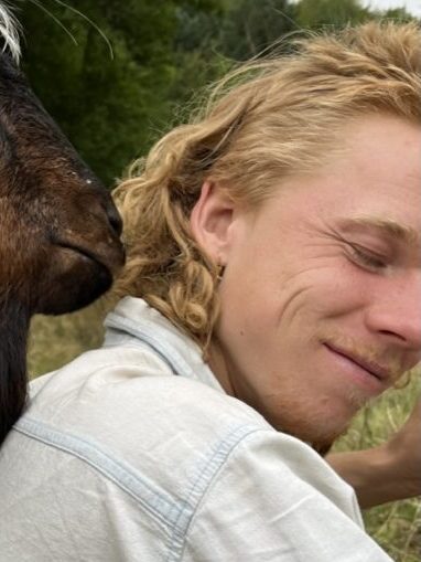 Gregor being kissed by a goat